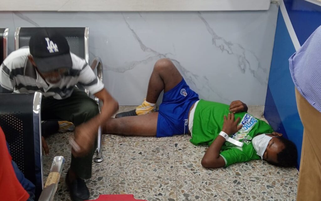 Usuarios sentados y acostados en el suelo por larga espera en el Universitario.