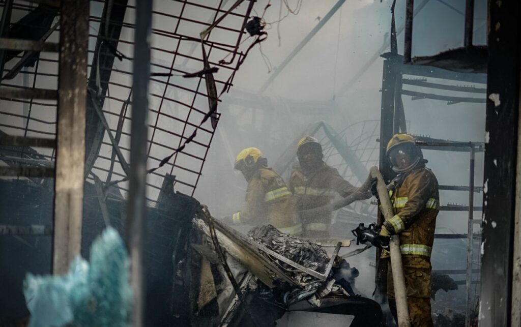 Equipo de bomberos retira escombros luego de controlar las llamas.