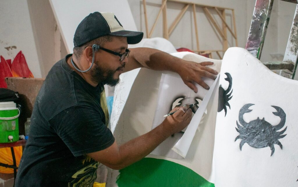 Escultor del gran Bolívar pinta detalles de una carroza del Desfile del Bando 2025.