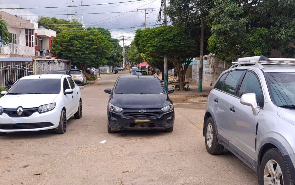 Vehículos mal parqueados bloquean el paso del camión recolector.
