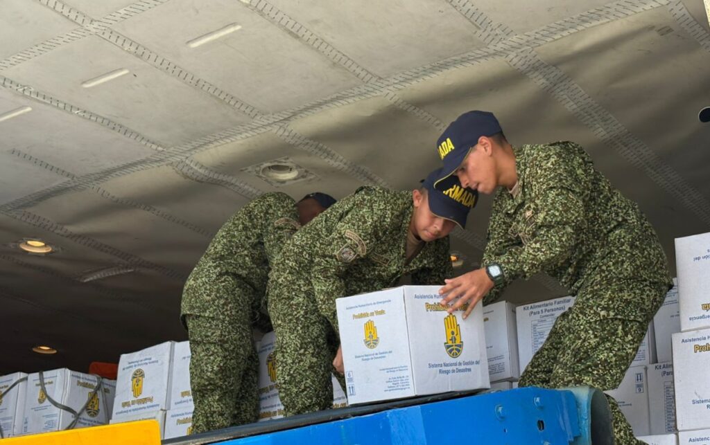 Voluntarios empacan sábanas y toldillos para envío humanitario.