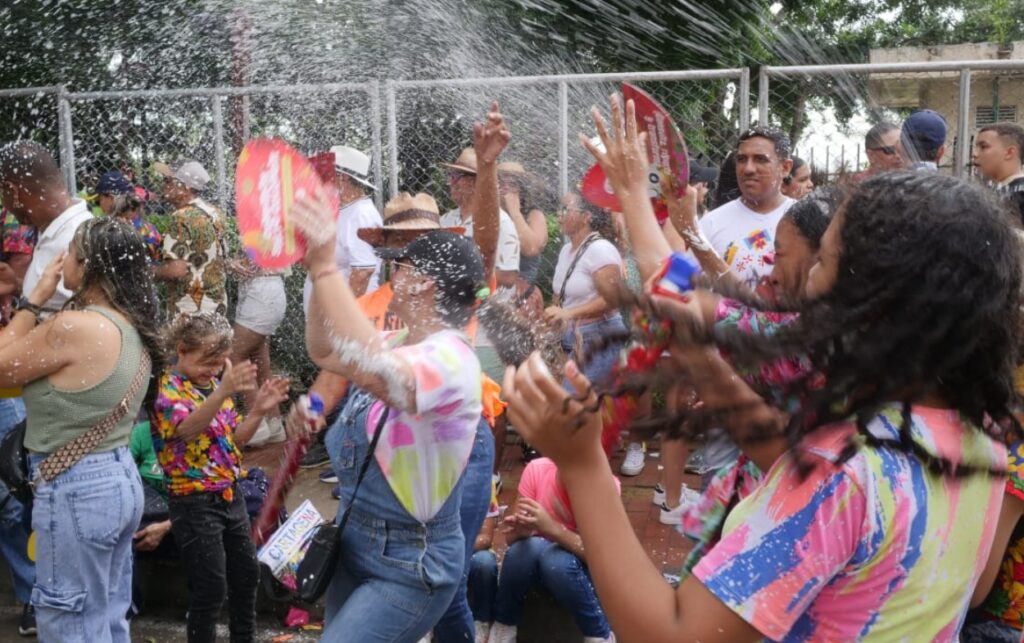 Asistentes bailando y recibiendo espuma en una jornada de las Fiestas de la Independencia..