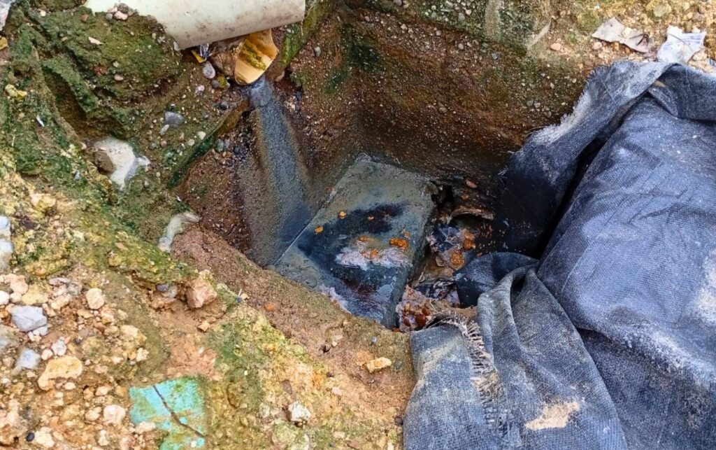 Comunidad denuncia fuga visible en un registro de alcantarillado expuesto, con agua saliendo de una tubería en la obra del Líbano