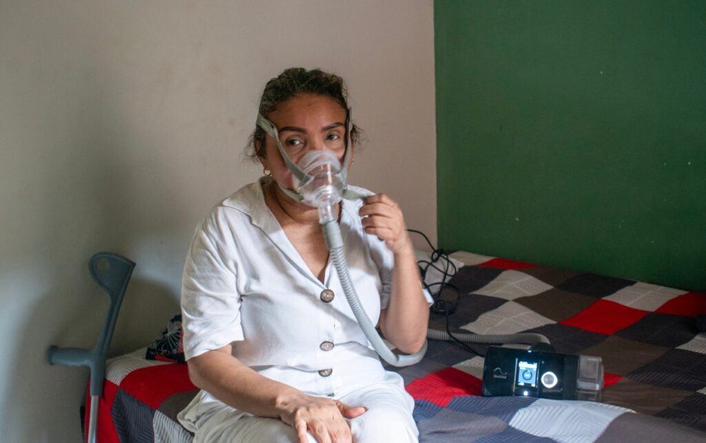 Enfermedades huérfanas_ Yulexis Rodríguez usando una máquina CPAP en su habitación como parte del tratamiento para la apnea del sueño. 
