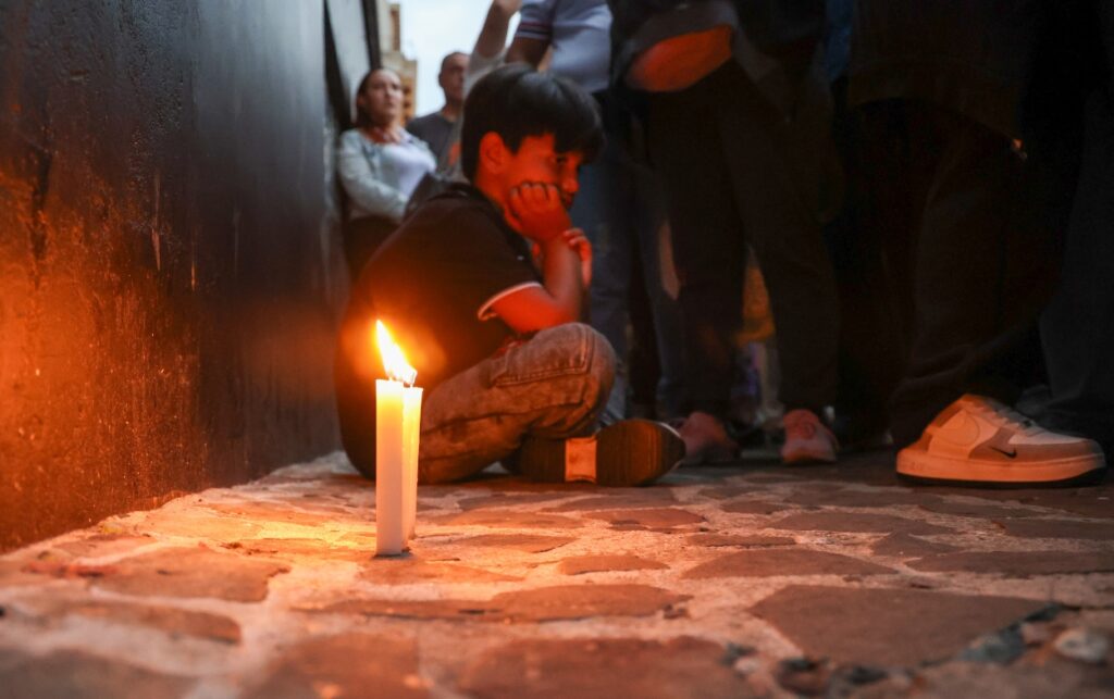 Bello está de luto, Niño sentado junto a una vela durante acto simbólico en el parque Santander