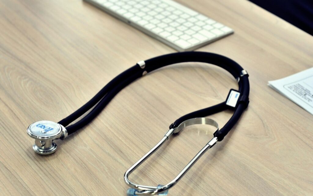 Humanización de la salud_ el estetoscopio simboliza la medicina clínica desplazada por la carga administrativa. 