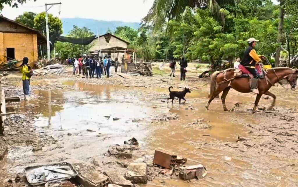 Habitantes del centro poblado Vanegas recorren calles cubiertas de lodo luego de la emergencia que dejó 60 familias afectadas por la creciente del río Lebrija. 