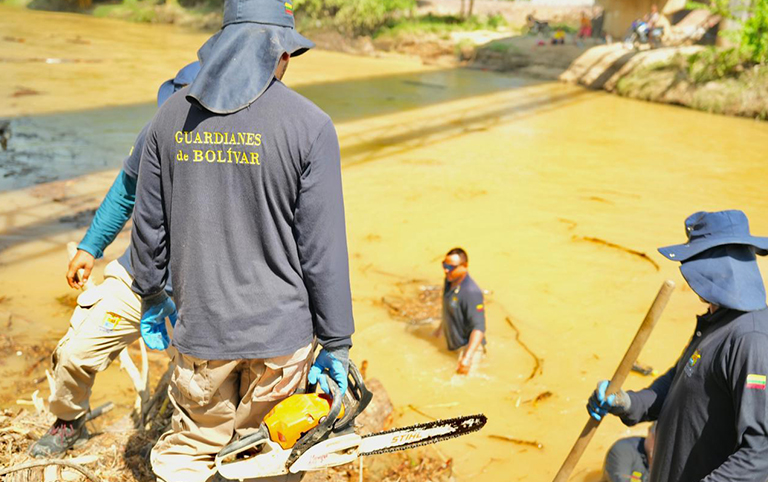 Equipo de Guardianes de Bolívar retirando lodo de una vivienda.