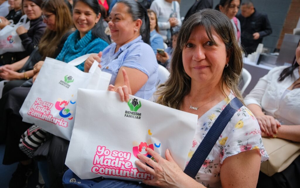 Participante sostiene bolsa del ICBF durante el anuncio que convierte a 2.300 madres comunitarias en empleadas públicas.