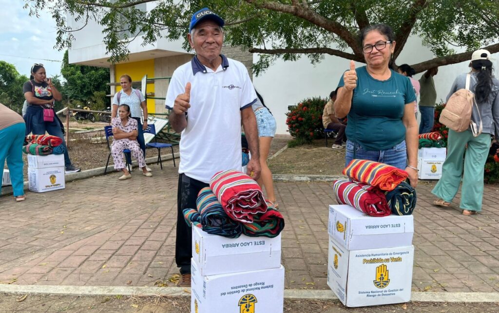 Personas damnificadas posan con kits de emergencia entregados por la UNGRD tras las 256 emergencias registradas por el frente frío atípico. 