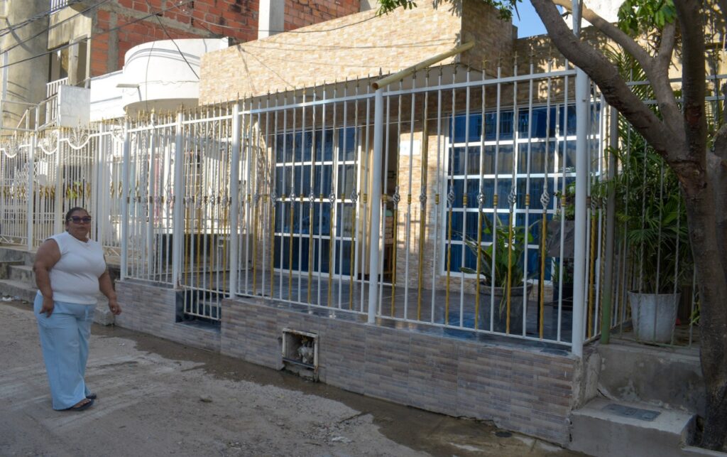 Residente de la manzana J camina frente a vivienda en calle destapada; Más de 40 años sin pavimento marcan el sector. 