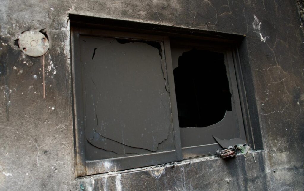 Ventana destruida por el incendio en vivienda de Los Calamares, evidencia de las pérdidas que llevaron al compromiso oficial de “En 3 meses tienen nueva casa”.