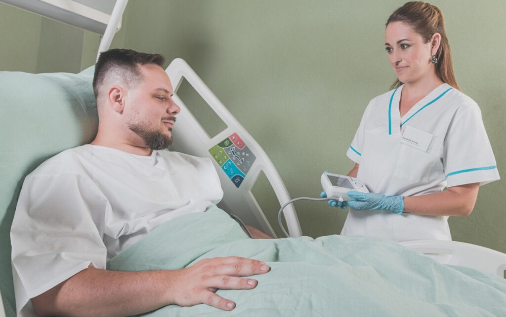 Decreto 0182 y atención médica en Colombia_ profesional de enfermería monitorea a paciente hospitalizado, símbolo del acceso a servicios de salud.