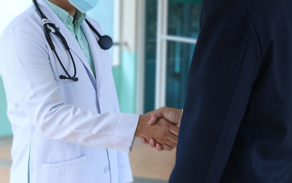 Decreto 0182 y sistema de salud: médico saluda a paciente en hospital, imagen que representa la continuidad en la atención que busca garantizar la norma. 