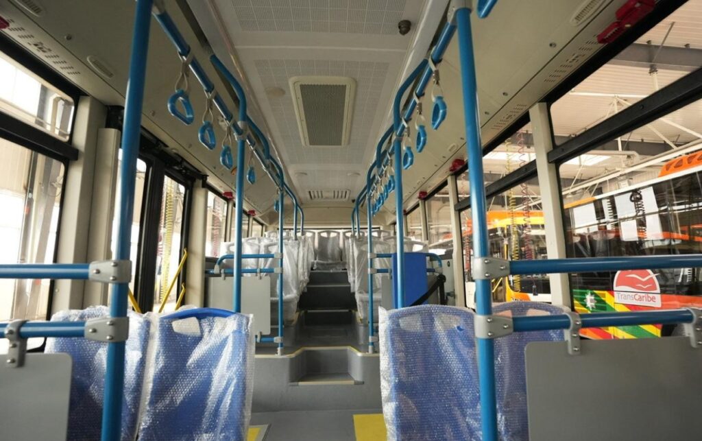 Interior de uno de los 55 buses de TransCaribe con asientos nuevos, barras de agarre y diseño accesible para usuarios.