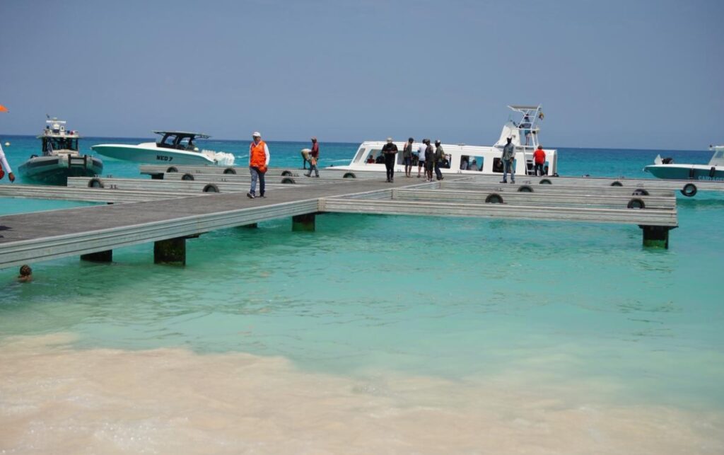 Reactivación de 300 metros de muelle  en Playa Blanca con embarcaciones operando y personal supervisando el embarque de turistas.