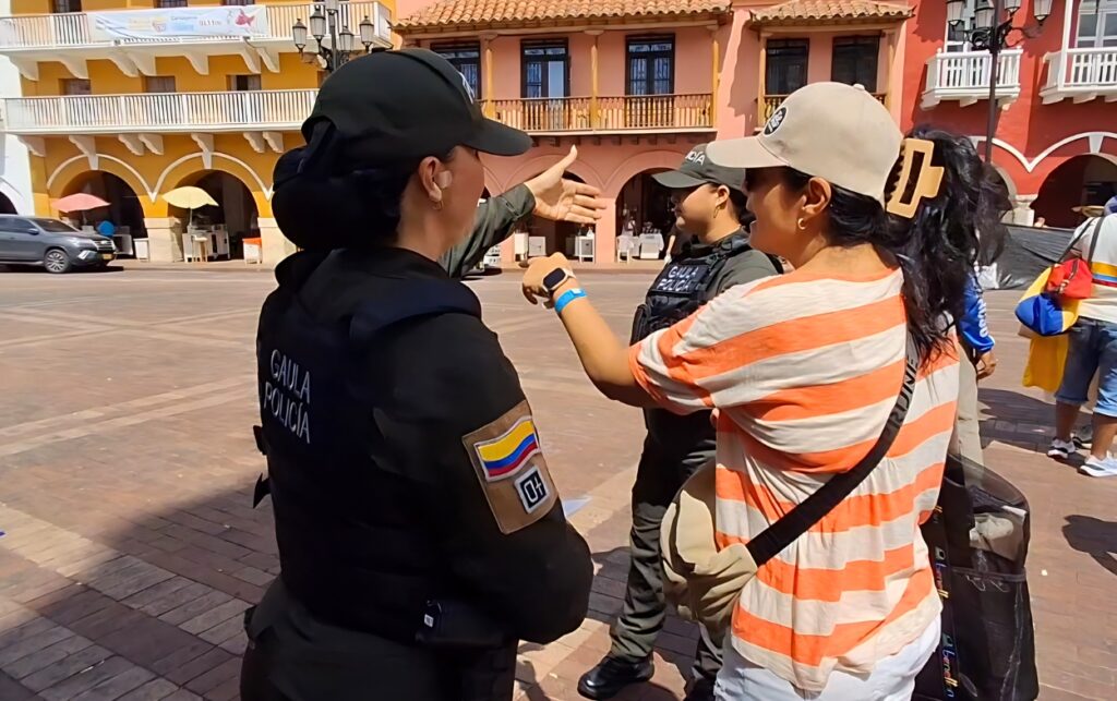 Campaña contra la extorsión en Cartagena uniformada del Gaula orienta a ciudadana en el Centro Histórico sobre cómo denunciar.