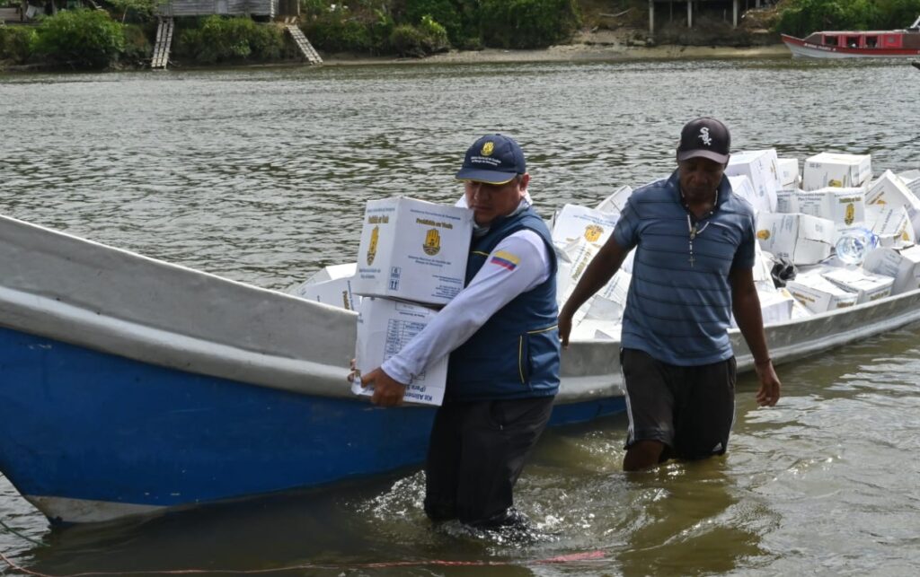 Entrega de kits humanitarios en zona ribereña_ funcionarios y comunidad descargan ayudas en medio de inundaciones en el Pacífico.