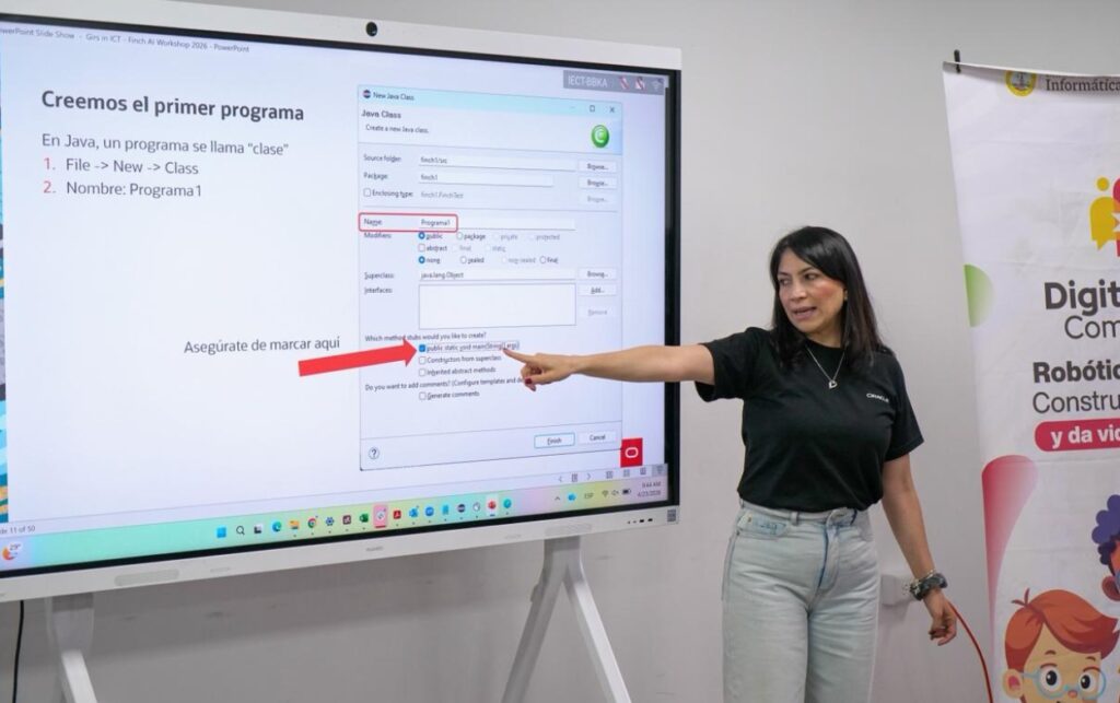 Instructora explica conceptos de programación en pantalla durante actividad educativa de robótica con estudiantes cartageneras