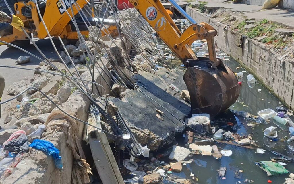 Intervención de canal en El Campestre con retroexcavadora retirando placas de concreto que obstruían el paso del agua en zona residencial de Cartagena.