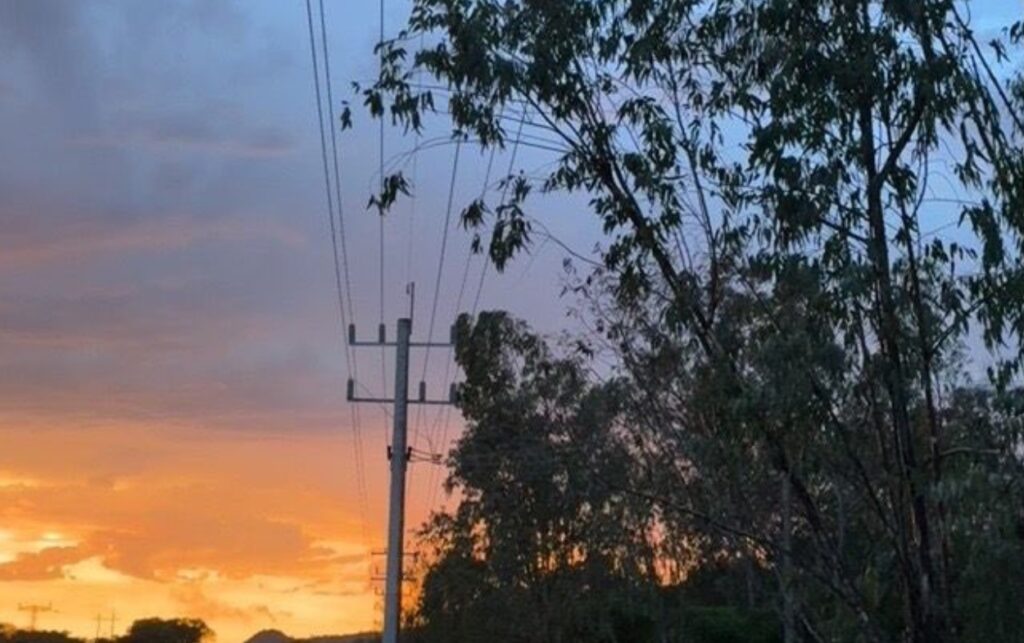 Líneas de transmisión eléctrica al atardecer reflejan el reto del Decreto 0393 para garantizar energía continua con sistemas de almacenamiento.