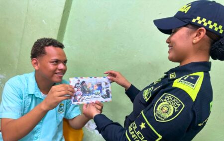 Estudiantes en Magangué entregan una tarjeta del “Correo de la Gratitud” a una uniformada de la Policía Comunitaria durante la jornada pedagógica.