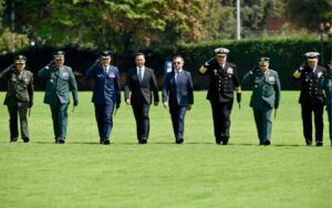 Presidente Gustavo Petro: “Ningún civil debe tener armas” Filas de altos mandos militares caminando en formación junto al presidente Gustavo Petro y otro funcionario, sobre una explanada verde