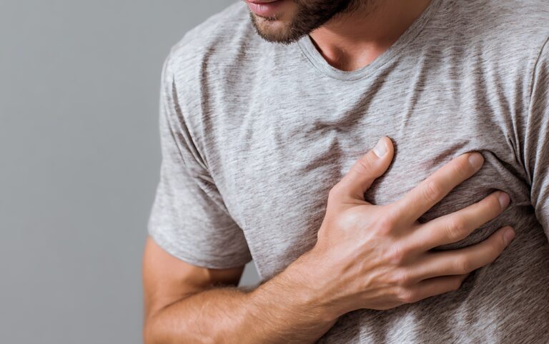 Hombre con dolor en el pecho, uno de los principales síntomas asociados a enfermedades cardiovasculares que requiere atención médica.