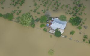 Vista aérea de viviendas rodeadas por inundaciones en zona rural, evidencia de la magnitud del fenómeno que deja 43.900 familias afectadas.